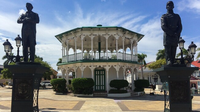 Dos estatuas a ambos lados de la pasarela que conduce a un mirador de estilo victoriano en la Plaza Independencia de Puerto Plata, República Dominicana