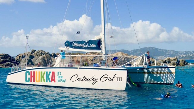 A private catamaran anchored in the water near Saint Thomas, with Guests swimming nearby