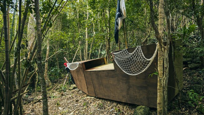 Um cenário de navio pirata de madeira com rede de cordas e uma bandeira, situado entre as árvores em Tortola, Ilhas Virgens Britânicas