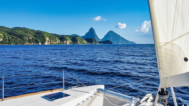 A view of the Pitons mountain peaks in Saint Lucia on board a luxury catamaran sailing in the water A view of the Pitons mountain peaks in Saint Lucia on board a luxury catamaran sailing in the water