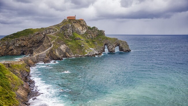 The islet of Gaztelugatxe, featuring a hermitage at its top and a winding walkway connecting it to the mainland