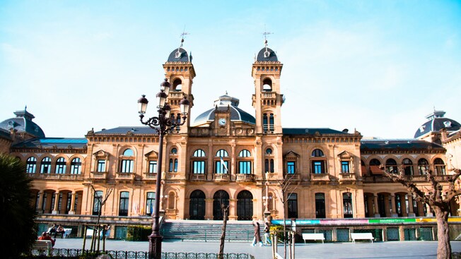 A historic building with 2 domed towers, arched windows and ornate architectural details