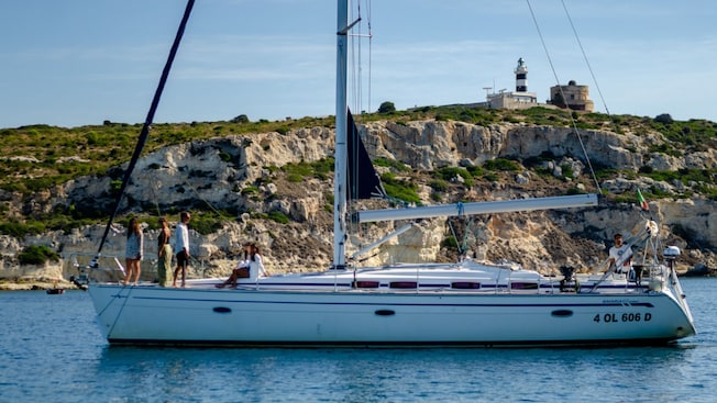 A sailboat with 5 passengers anchored near the coastline of Cagliari A sailboat with 5 passengers anchored near the coastline of Cagliari