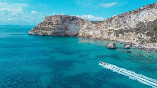 A Zodiac boat speeding through waters near the Sella del Diavolo promontory in the Gulf of Cagliari