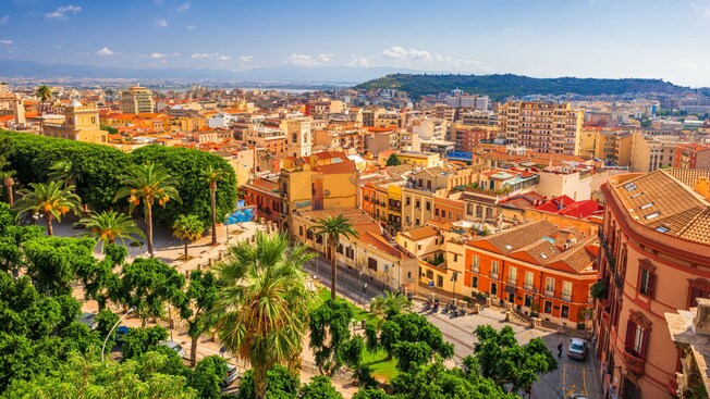 Cityscape of Cagliari, Italy, featuring terracotta roof building and a sprawling hillside