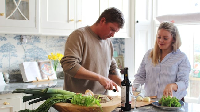 A couple preparing a meal together with fresh vegetables in a modern kitchen A couple preparing a meal together with fresh vegetables in a modern kitchen