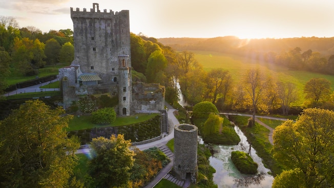 Blarney Castle on a hill surrounded by trees at sunrise Blarney Castle on a hill surrounded by trees at sunrise
