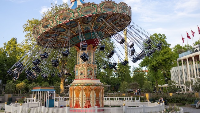 An ornate swing carousel in motion at Tivoli Gardens amusement park in Copenhagen, Denmark An ornate swing carousel in motion at Tivoli Gardens amusement park in Copenhagen, Denmark
