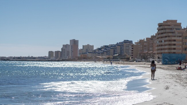 Guests strolling along and relaxing on a sandy beach