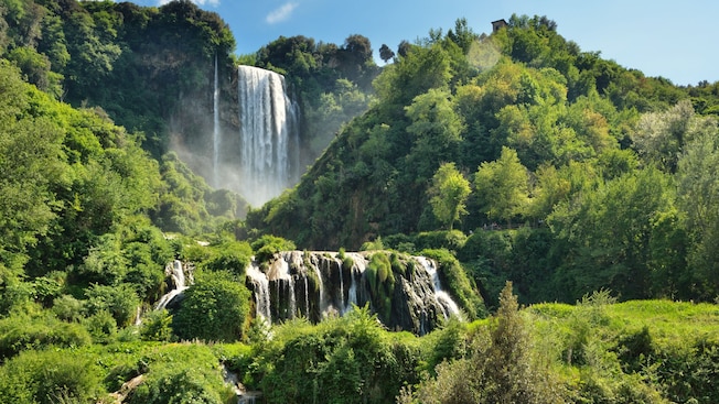 Una serie de cascadas que fluyen por los exuberantes acantilados verdes en la cascada de Marmore Una serie de cascadas que fluyen por los exuberantes acantilados verdes en la cascada de Marmore