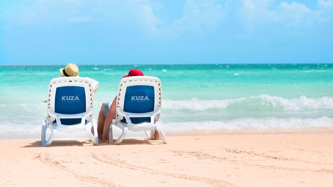 Two Guests sitting in lounge chairs on Kuza Beach