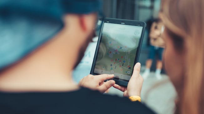 Two people examining a map on a tablet Two people examining a map on a tablet