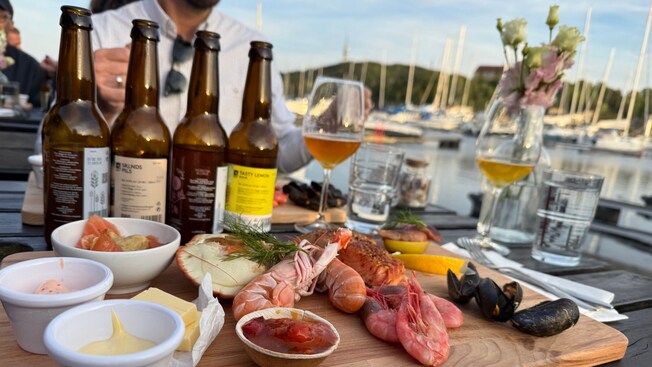 A platter of Norwegian seafood and sauces with 4 bottles of beer for tasting