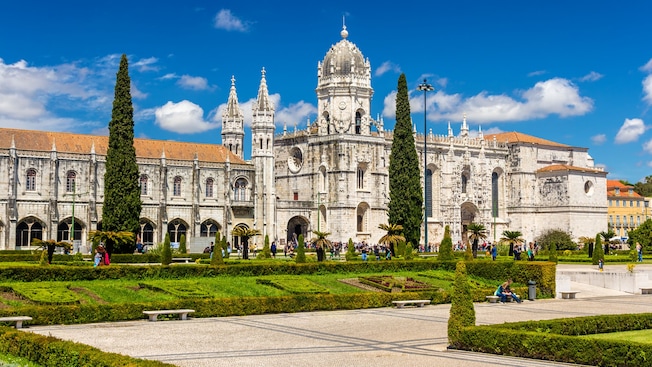 Guests walking through the gardens of Jerónimos Monastery in Lisbon, Portugal