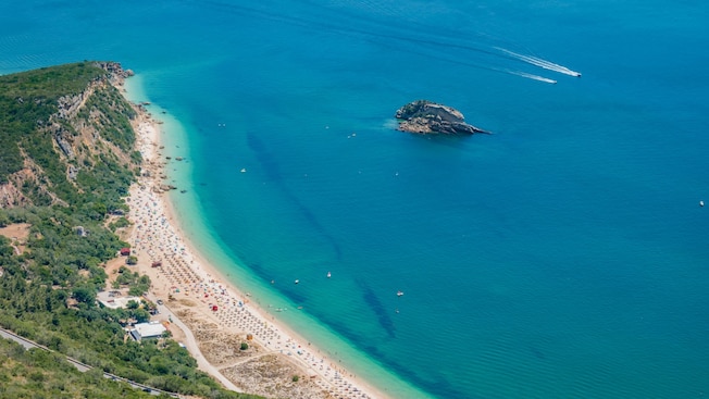 A crescent beach along the waters of Sesimbra, Portugal