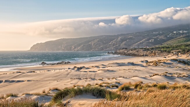 The sands of Guincho Beach near a mountain in Cascais, Portugal