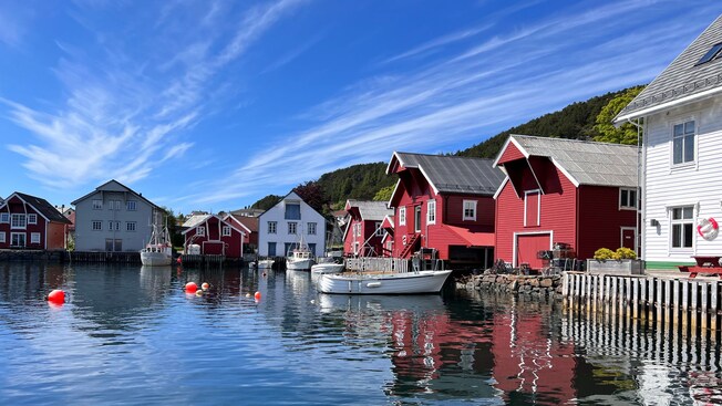 Wooden cottages lining the waterfront with boats docked near the shore