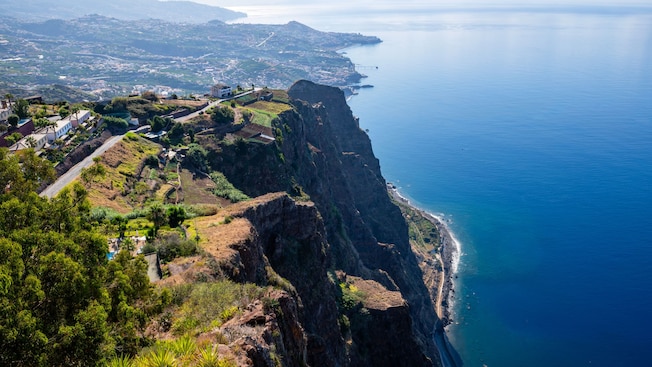 An aerial view of Cabo Girão sea cliff and Câmara de Lobos town in the distance An aerial view of Cabo Girão sea cliff and Câmara de Lobos town in the distance