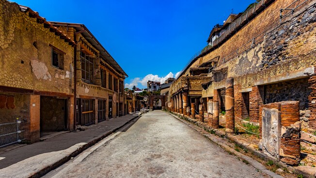 Una calle vacía bordeada por antiguos edificios de piedra en la ciudad romana de Herculano