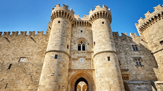 Un castillo de piedra medieval con torres cilíndricas, una entrada arqueada e intrincados detalles de piedra Un castillo de piedra medieval con torres cilíndricas, una entrada arqueada e intrincados detalles de piedra