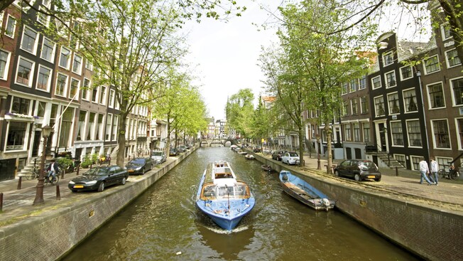Un bote turístico navegando por los canales de Ámsterdam, Países Bajos