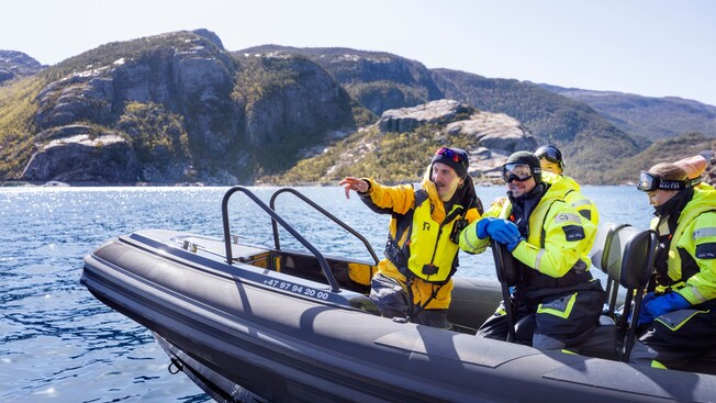 A guide pointing something out to Guests riding in a rigid inflatable boat