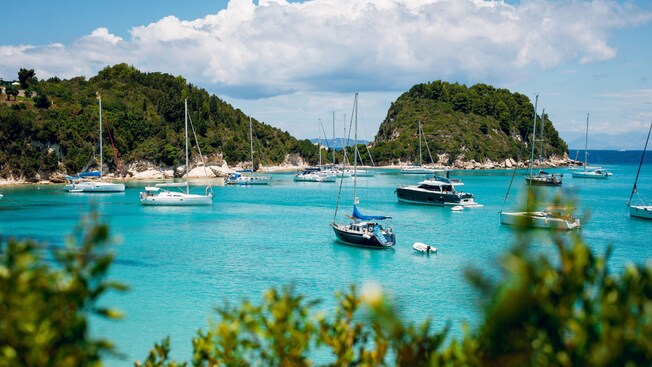 Una bahía en Corfú, Grecia, con yates y veleros flotando en el agua