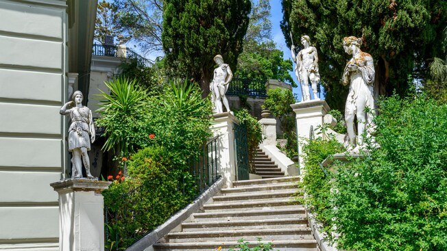 Stairs surrounded by statues leading to the Terrace of the Muses at Achilleion Palace in Corfu, Greece