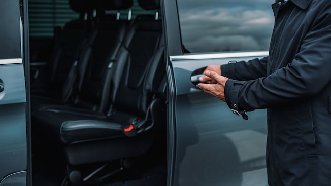 A driver opening the door of a private van A driver opening the door of a private van