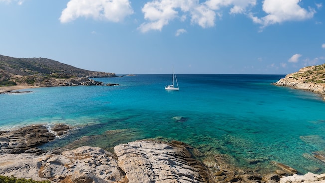 A sailboat anchored in a cove along the Rhodes coastline