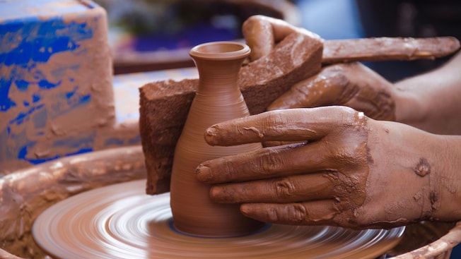 A Guest shaping a clay vase on a pottery wheel