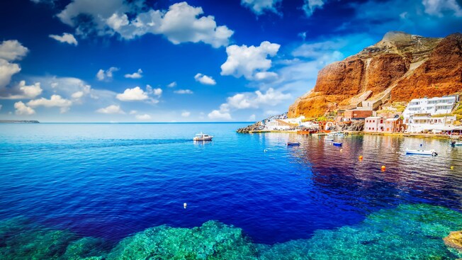 A coastal village with buildings nestled along rocky cliffs overlooking the water