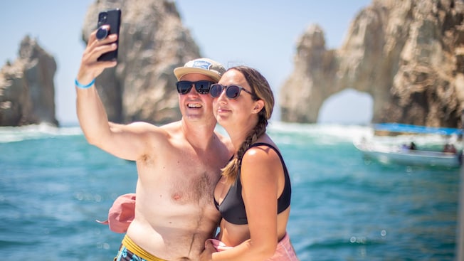 Guests taking a selfie aboard a catamaran near El Arco rock formation in Cabo San Lucas Guests taking a selfie aboard a catamaran near El Arco rock formation in Cabo San Lucas
