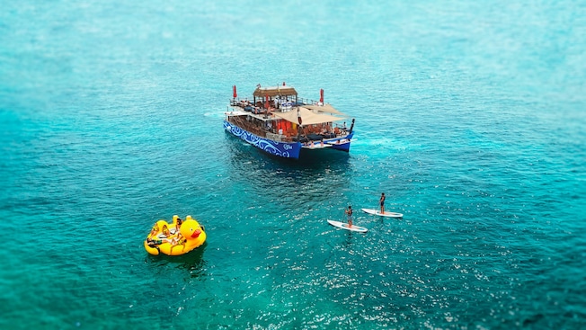 Aerial view of Guests paddleboarding and floating on a giant inflatable duck near BLU Floating Ocean Club