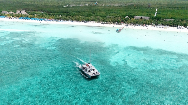 A catamaran cruises on the water off Kuza Beach in Cozumel, Mexico A catamaran cruises on the water off Kuza Beach in Cozumel, Mexico