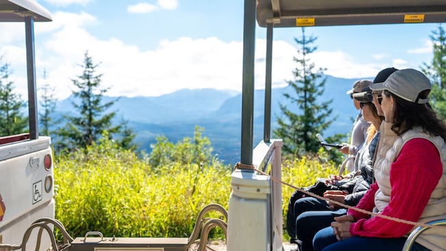 Three Guests riding a tram and enjoying views of Hoonah Mountain in Icy Strait, Alaska Three Guests riding a tram and enjoying views of Hoonah Mountain in Icy Strait, Alaska