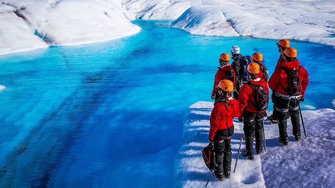 Visitantes junto a una grieta de hielo en un glaciar Visitantes junto a una grieta de hielo en un glaciar