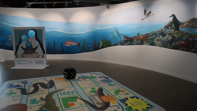 A children's area featuring a large mural depicting an underwater scene with various marine animals A children's area featuring a large mural depicting an underwater scene with various marine animals