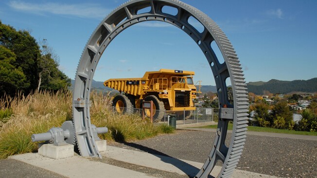 An exhibit at the Martha Gold Mine featuring a large gear and dump truck