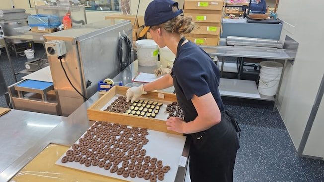 Una mujer armando galletas de chocolate en The Silky Oak Chocolate Company Una mujer armando galletas de chocolate en The Silky Oak Chocolate Company