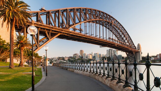 A harborside walkway traveling under the Sydney Harbour Bridge