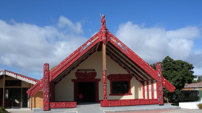 A traditional carved wooden meeting house at Māori cultural site