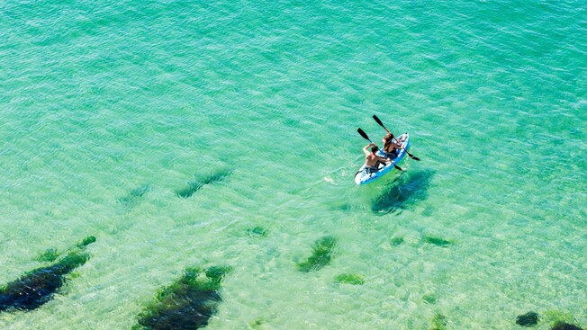 Two people kayaking in the waters of Laguna Del Condado