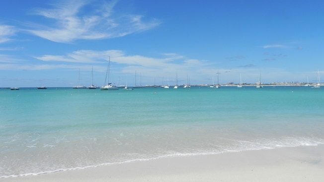 A shoreline with anchored boats in the distance A shoreline with anchored boats in the distance