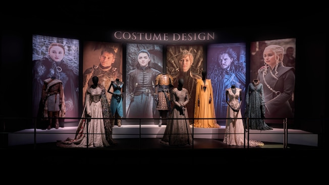 Telas representando personagens da série HBO, Game of Thrones e manequins vestindo trajes originais com uma placa dizendo ‘Costume Design’ ('Figurinista') Telas representando personagens da série HBO, Game of Thrones e manequins vestindo trajes originais com uma placa dizendo ‘Costume Design’ ('Figurinista')