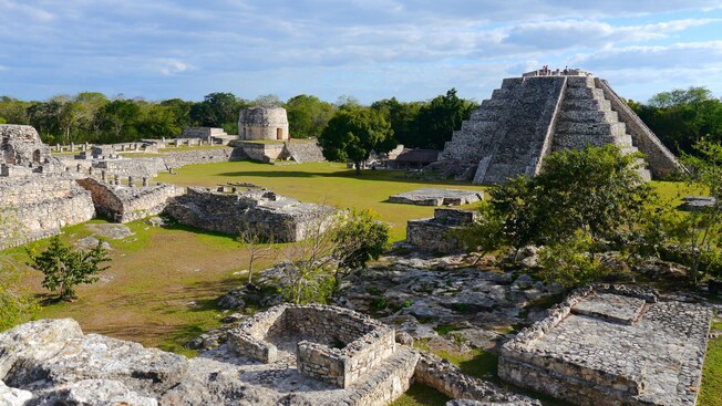 An outdoor plaza filled with ancient Mayan ruins