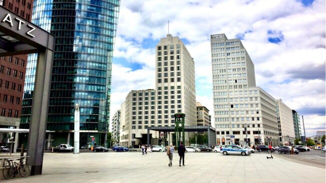 A wide pedestrian walkway with modern skyscrapers