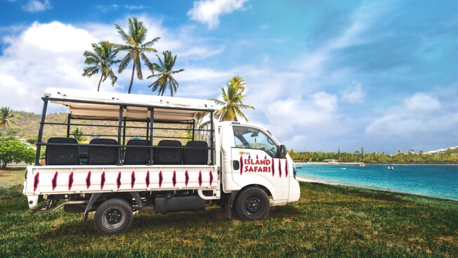 An open air truck parked on grass next to water in Saint Johns, Antigua