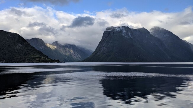 The Hjørundfjorden in Norway with a body of water and lush mountains