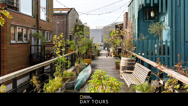 Several houses along a plant lined pier, with text below that says 'National Geographic Day Tours'